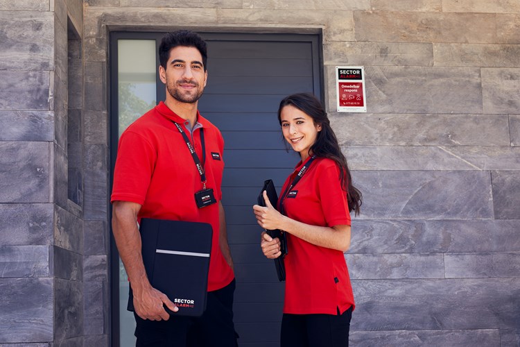 Two workers from Sector Alarm photograph